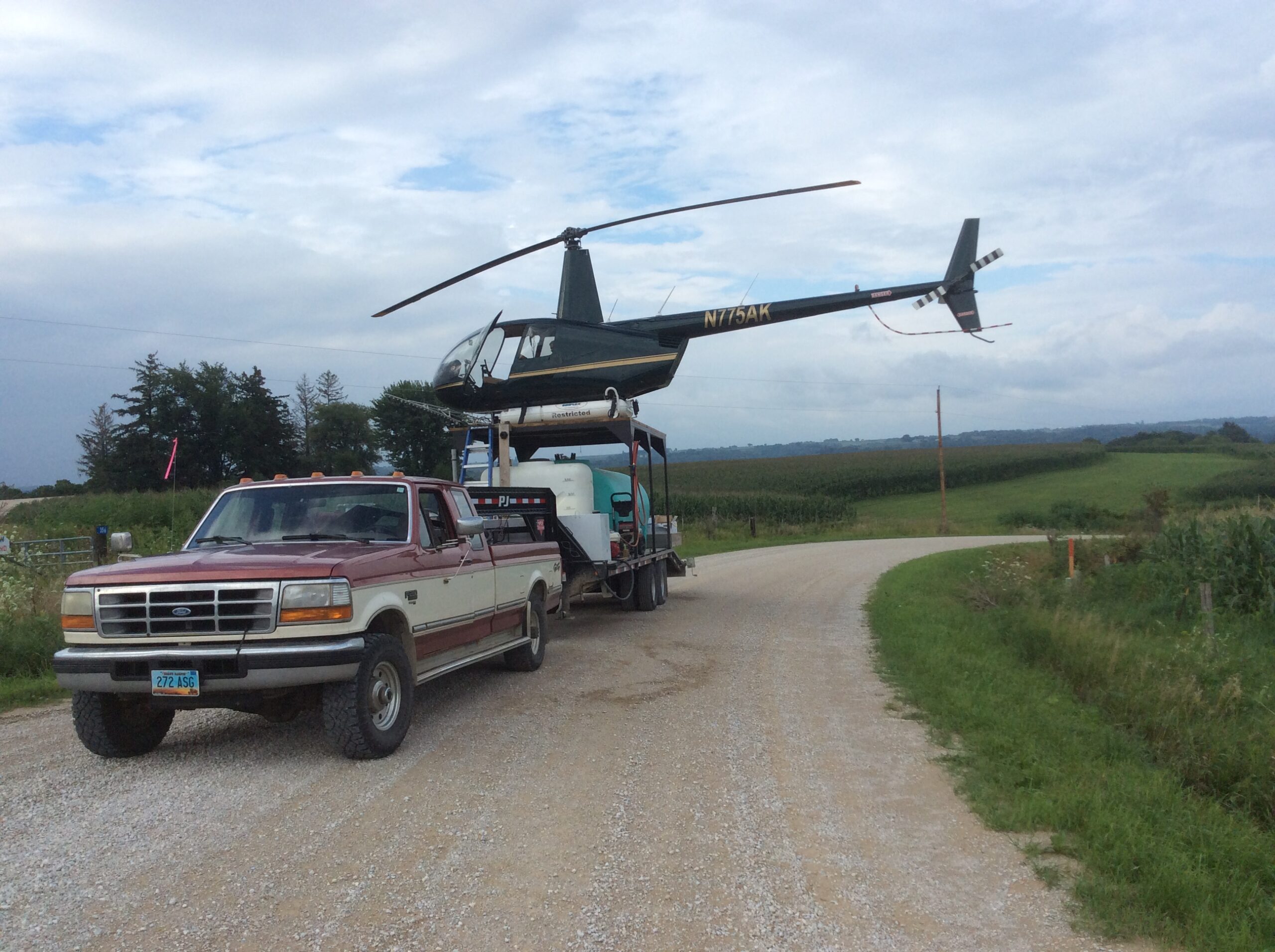 Crop dusting helicopter refilling on a mobile mix trailer