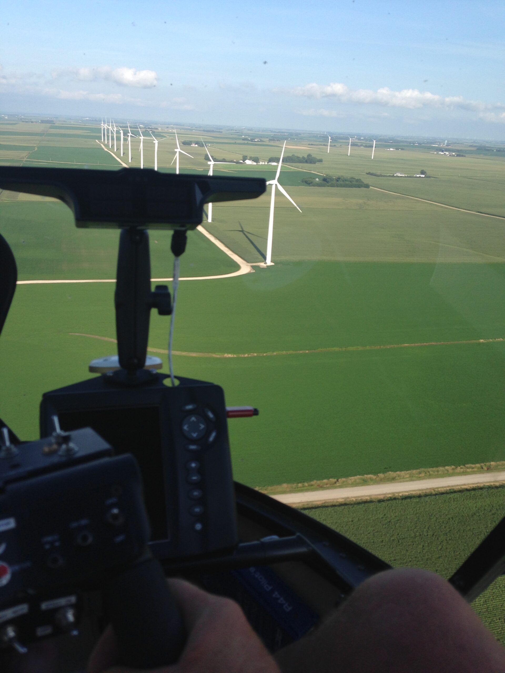 aerial spraying helicopter looking over a large field of crops